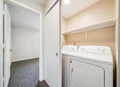 Thumbnail 32 of 35 - A small laundry room with a washer and dryer.