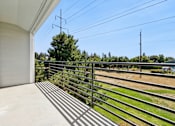 Thumbnail 65 of 74 - A balcony with a metal railing overlooks a field.