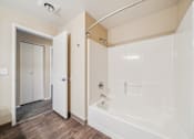 Thumbnail 34 of 35 - A white bathroom with a tub and a walk-in shower.