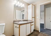 Thumbnail 35 of 35 - A bathroom with a sink, mirror, and toilet.