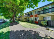 Thumbnail 6 of 44 - a street view of a row of townhomes with cars parked on the side of the