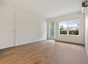Thumbnail 9 of 46 - A room with a white door and a window with a view of the outside.