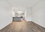 Thumbnail 11 of 46 - A kitchen with white walls and wooden floors.