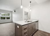 Thumbnail 15 of 46 - A kitchen with a sink, cabinets, and a window.