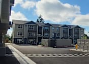 Thumbnail 40 of 46 - A parking lot in front of a large apartment complex.