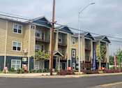 Thumbnail 32 of 46 - Apartment building with a grey and tan exterior.