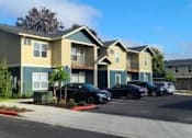 Thumbnail 46 of 46 - A row of townhouses with cars parked in front.