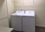 Thumbnail 33 of 46 - Two white washing machines in a small room.