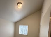 Thumbnail 16 of 18 - A room with a carpeted floor and a window with blinds.
