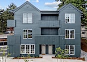 Thumbnail 41 of 50 - A modern two-story house with a grey exterior and white windows.