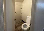 Thumbnail 7 of 18 - A white toilet in a narrow hallway.