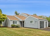 Thumbnail 5 of 40 - A house with a grey siding and a brown roof.