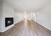 Thumbnail 19 of 40 - A long hallway with a fireplace on the left side.