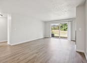Thumbnail 20 of 40 - A room with a sliding glass door leading to a balcony.