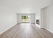 Thumbnail 21 of 40 - A spacious room with a fireplace and sliding glass doors.