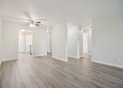 Thumbnail 22 of 40 - A room with a ceiling fan and wood flooring.
