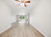 Thumbnail 23 of 40 - A room with a ceiling fan and wooden flooring.