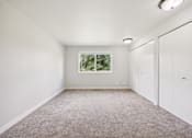 Thumbnail 30 of 40 - A room with a window and a carpeted floor.