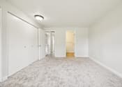 Thumbnail 31 of 40 - A long hallway with carpeted floors and white walls.