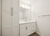 Thumbnail 33 of 40 - A white bathroom with a sink and a mirror.