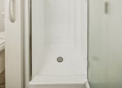 Thumbnail 35 of 40 - A white shower stall with a door and a shower head.
