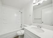 Thumbnail 39 of 40 - A white bathroom with a toilet, sink, and bathtub.