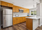 Thumbnail 40 of 40 - A kitchen with wooden cabinets and a white counter.