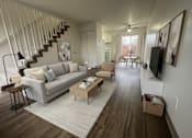 Thumbnail 1 of 31 - A living room with a grey couch and a wooden floor.