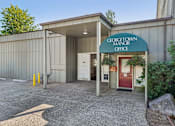 Thumbnail 27 of 38 - The Georgetown Manor Office is a small building with a red door and a green awning.