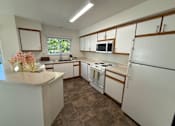 Thumbnail 8 of 56 - A kitchen with white cabinets and a tiled floor.