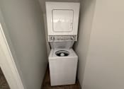 Thumbnail 15 of 56 - A white toilet with a built-in washing machine is in a small, white-walled bathroom.