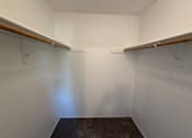 Thumbnail 14 of 56 - A small, empty room with a carpeted floor and two wooden shelves.