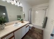 Thumbnail 10 of 56 - A bathroom with a sink, mirror, and shower.
