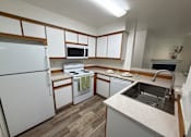 Thumbnail 18 of 56 - A kitchen with white appliances and wooden cabinets.