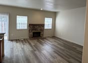 Thumbnail 5 of 18 - A room with a fireplace and wood flooring.