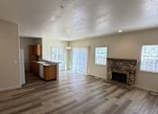 Thumbnail 3 of 18 - A room with a fireplace and wooden floors.