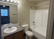 Thumbnail 14 of 18 - A bathroom with a sink, toilet, and bathtub.