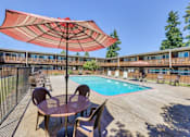 Thumbnail 9 of 17 - Pool deck with table and chairs Camille Court Apartments Milwaukie, OR