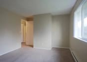 Thumbnail 58 of 64 - A room with a carpeted floor and a doorway leading to another room.