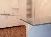 Thumbnail 55 of 64 - A kitchen with white cabinets and a wooden floor.