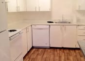 Thumbnail 59 of 64 - A white kitchen with wooden floors and white appliances.