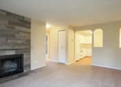 Thumbnail 60 of 64 - A living room with a stone fireplace and a doorway leading to another room.