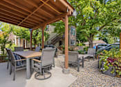 Thumbnail 2 of 56 - A patio with a table and chairs under a wooden roof.