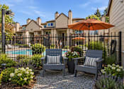 Thumbnail 28 of 56 - Two grey chairs are placed in front of a pool.