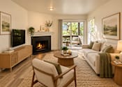 Thumbnail 16 of 56 - A living room with a fireplace and a couch.