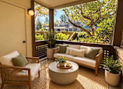 Thumbnail 21 of 56 - A patio with a couch, chair, and table with a plant on it.