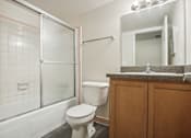 Thumbnail 12 of 12 - A white toilet sits in a bathroom next to a glass shower door.