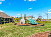 Thumbnail 7 of 22 - A playground with a green slide and a sandbox.