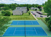 Thumbnail 2 of 8 - an aerial view of a tennis court with houses in the background