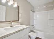 Thumbnail 18 of 27 - A white bathroom with a sink, toilet, and bathtub.